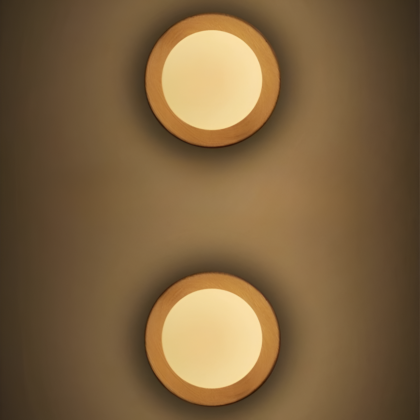 Dos apliques de pared nórdicos de madera iluminados sobre una pared cálida.