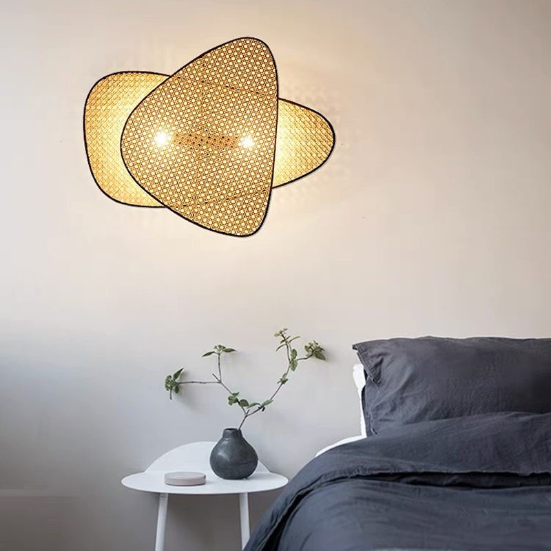 Eine Wandleuchte aus Rattan leuchtet in einer Schlafzimmerszene