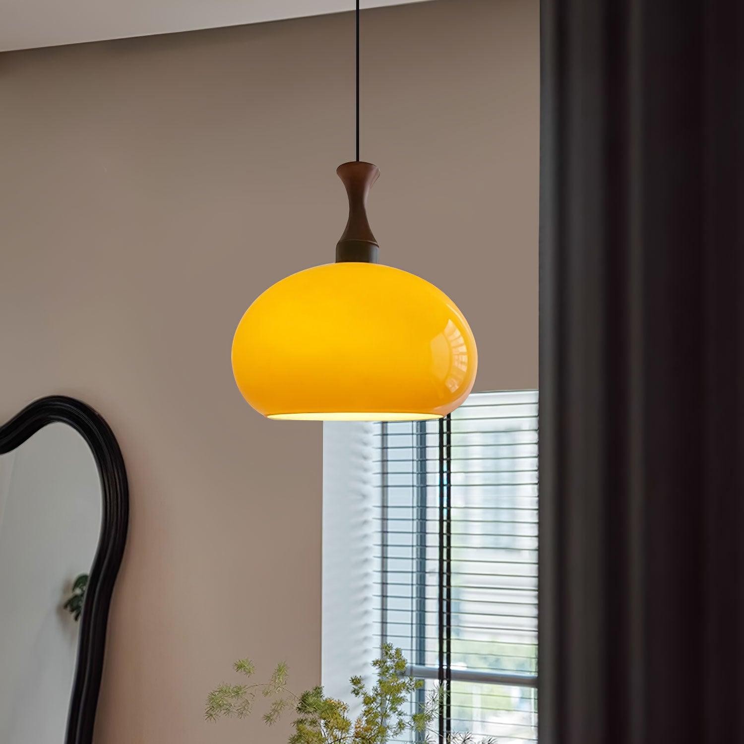 Pomarańczowa lampa wisząca zainstalowana w pobliżu okna