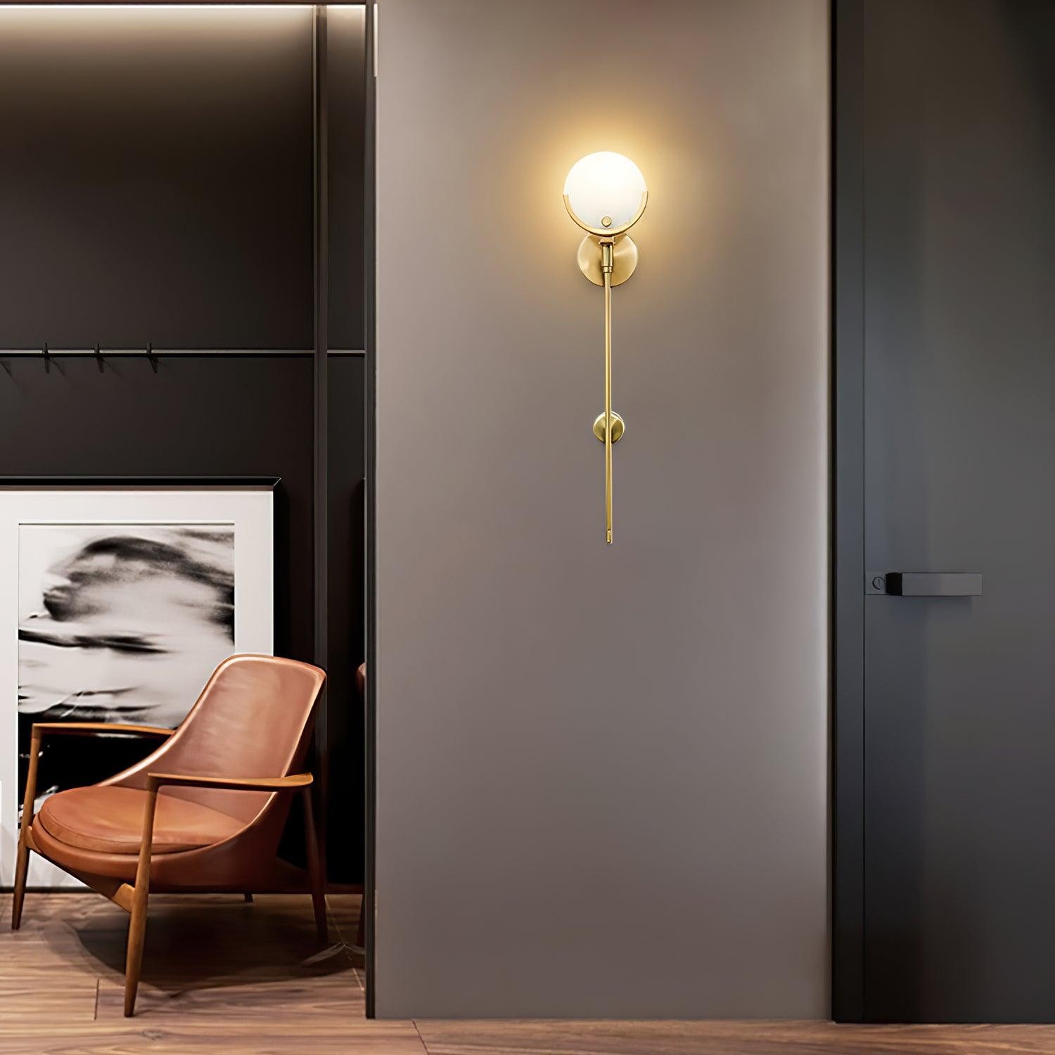 Zapalona mosiężna lampa ścienna na ciemnej ścianie