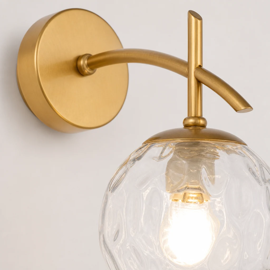 Detalle en primer plano de la lámpara de pared Orbe Celestial, donde se aprecian el brazo metálico y la esfera de cristal.