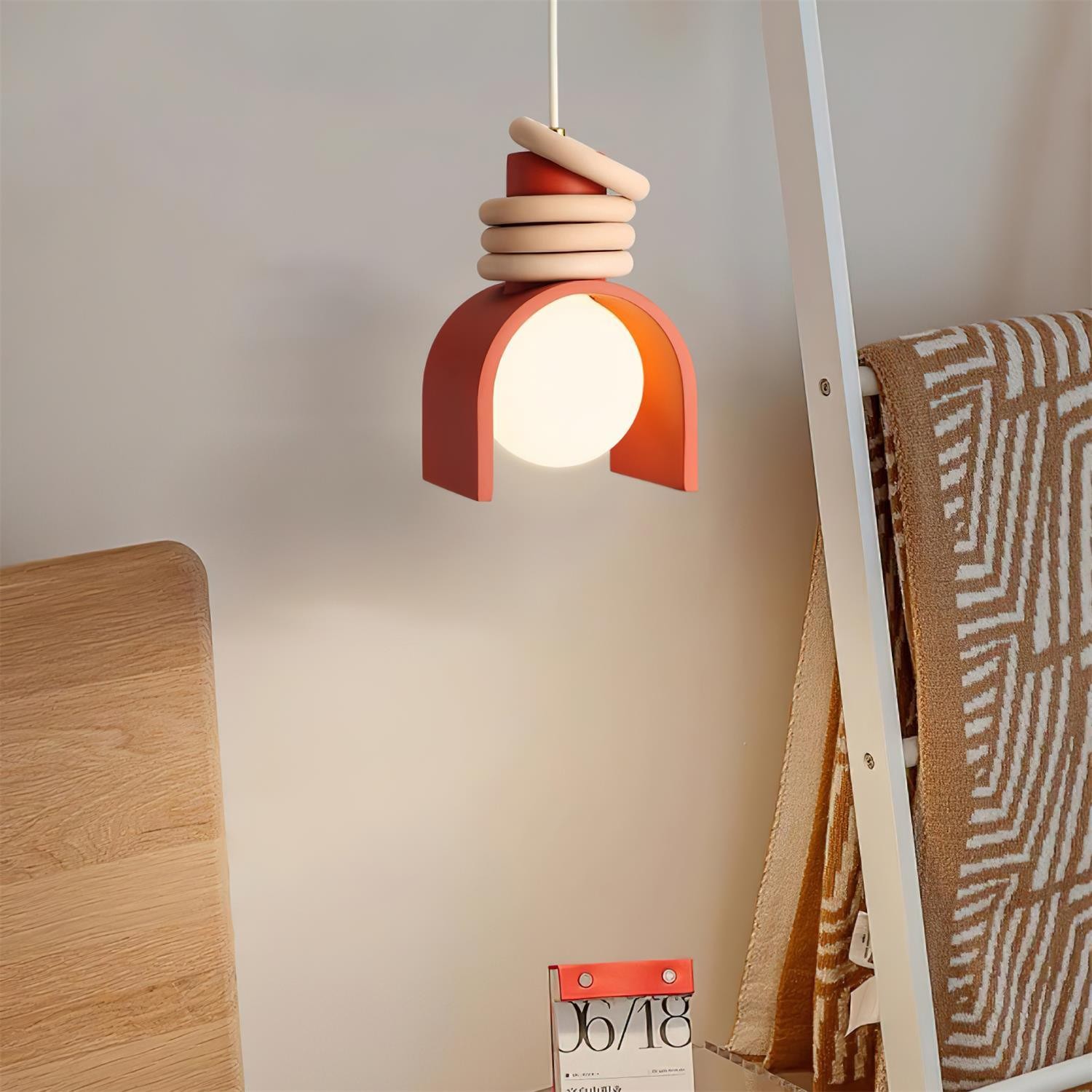 Czerwona lampa wisząca zainstalowana obok łóżka