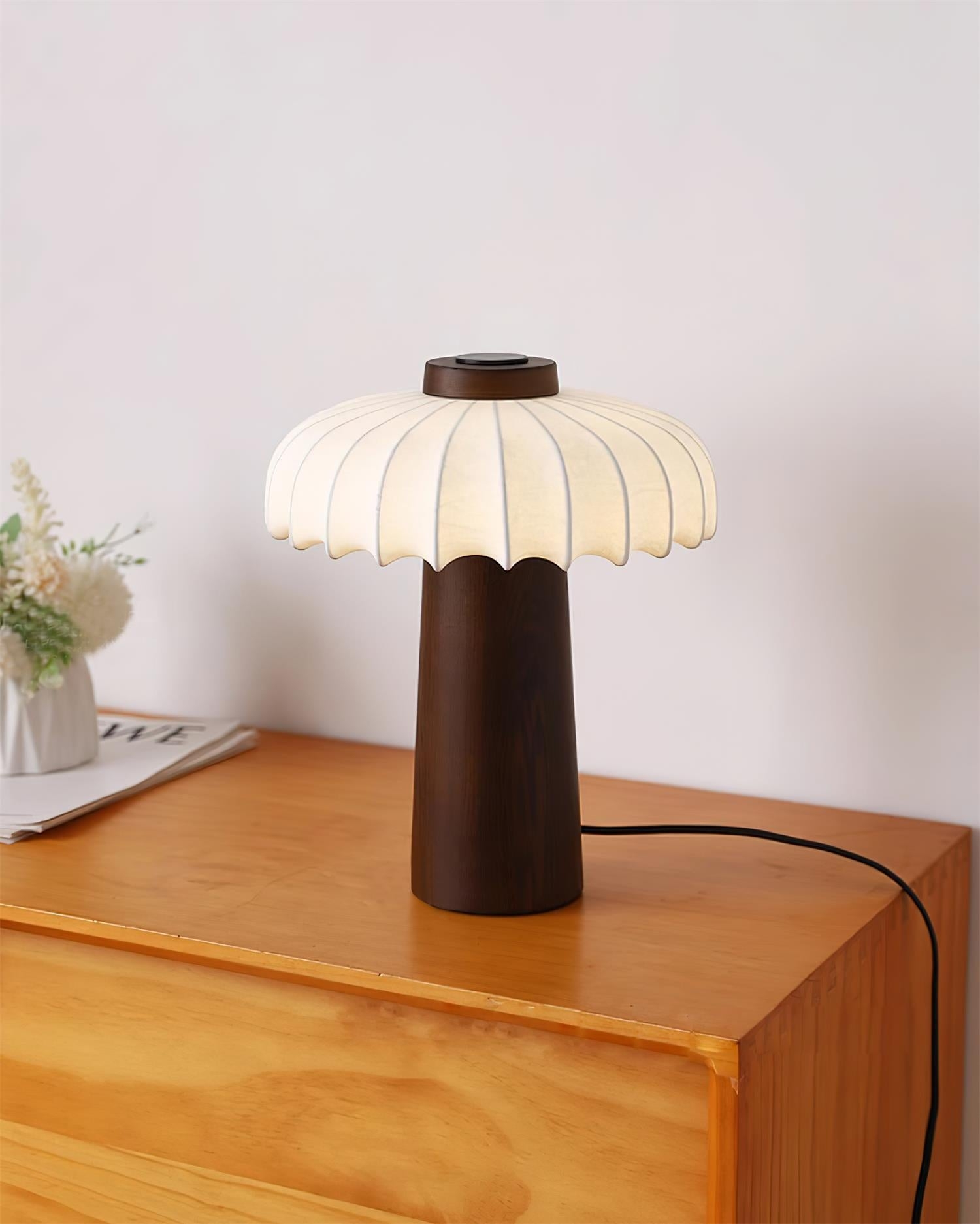 Lampa stołowa Juego z ciemnego drewna na szafce z dekorem