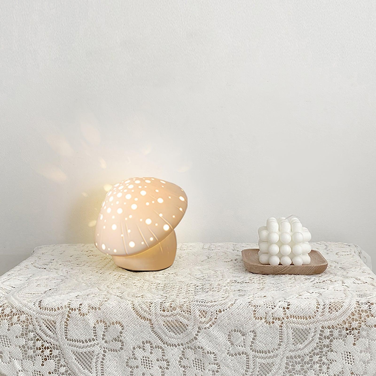 Zapalona lampa grzybkowa na stole pokrytym koronką z miękką projekcją ścienną