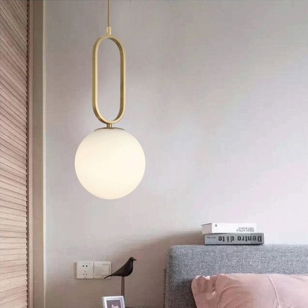 Oval ringformet pendellampe montert ved siden av sengen