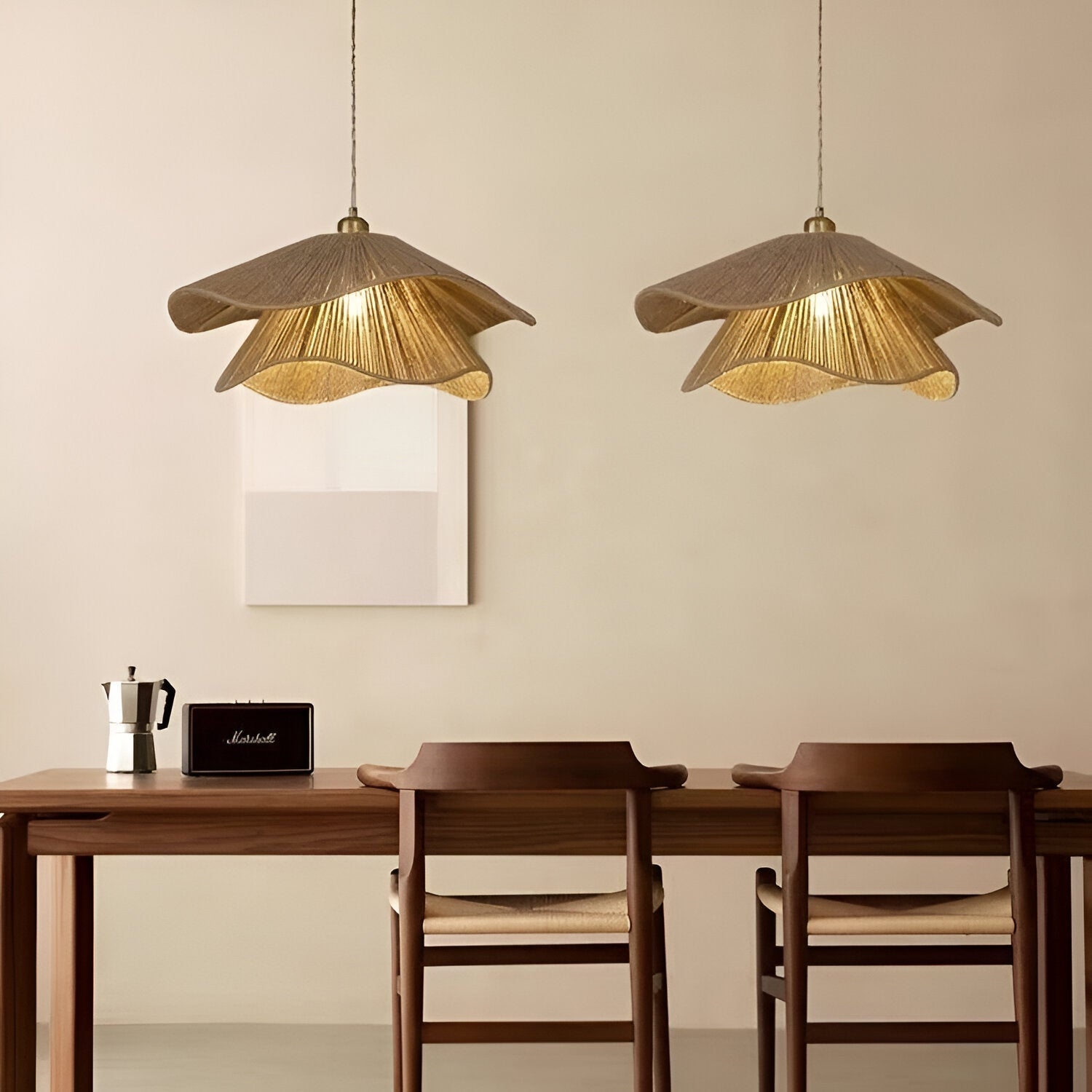 Dos lámparas colgantes iluminadas sobre una mesa de trabajo.