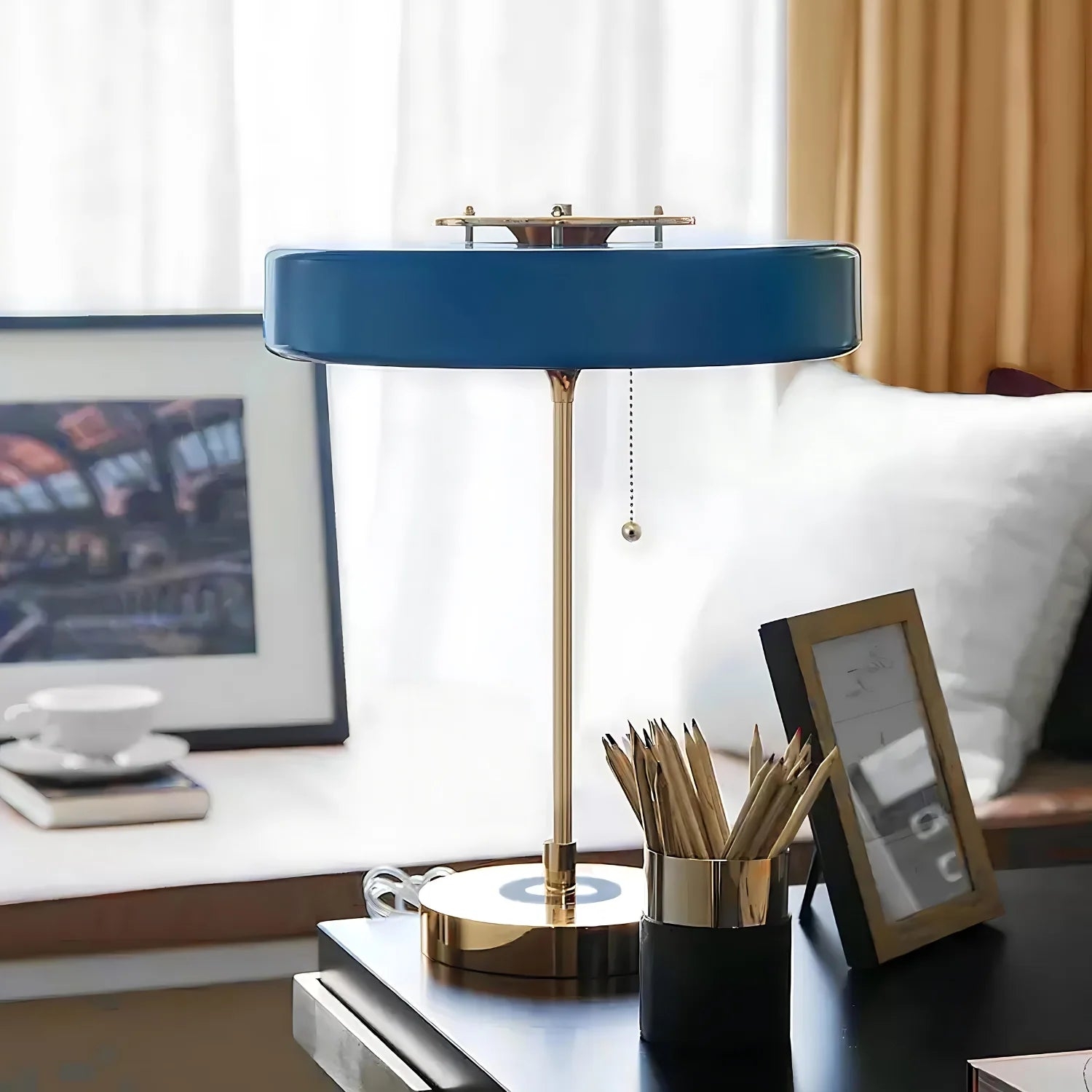 Niebieska lampa stołowa D803 na jasnym biurku z dekoracją