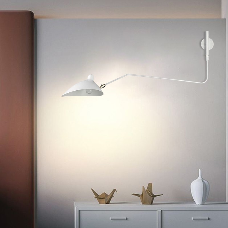 Hvit vegglampe over et skap med synlig lysstråle