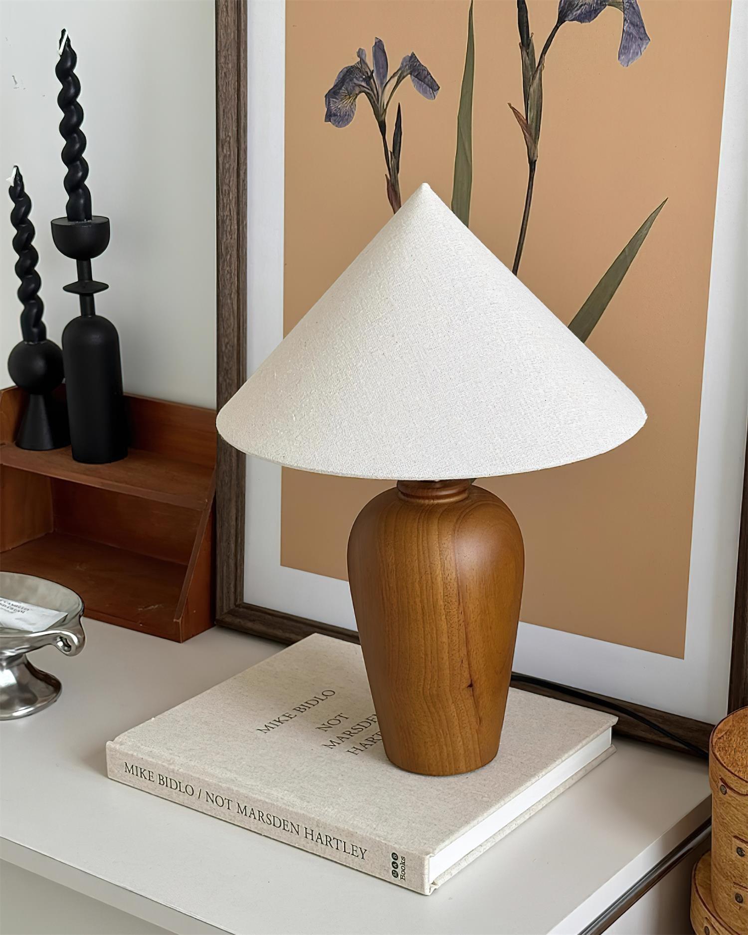 Lampa Brayden na ułożonych książkach z dekoracją w ramkach