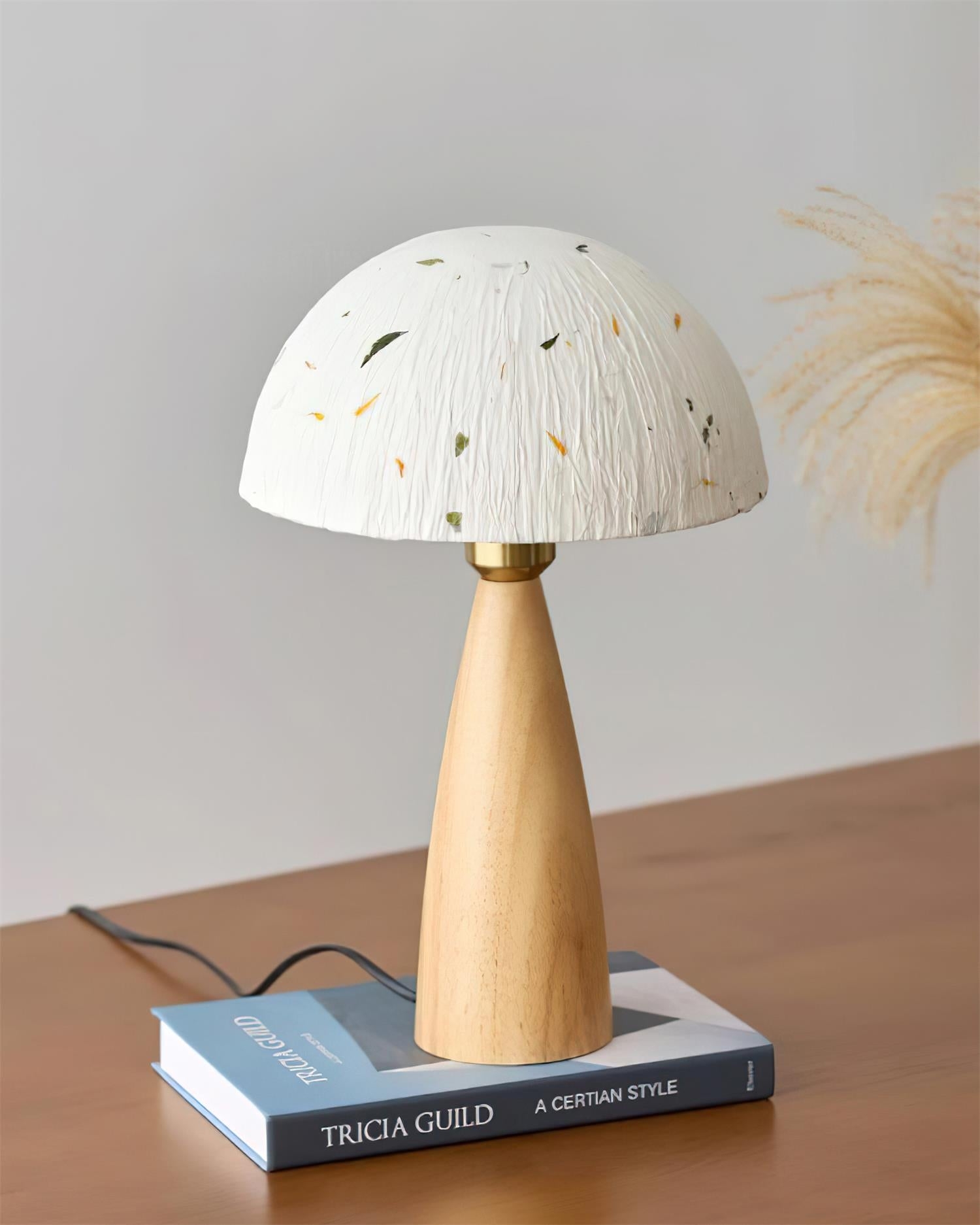 Lampa stołowa Kent Wood D62 eksponowana na książkach z dekoracją roślinną