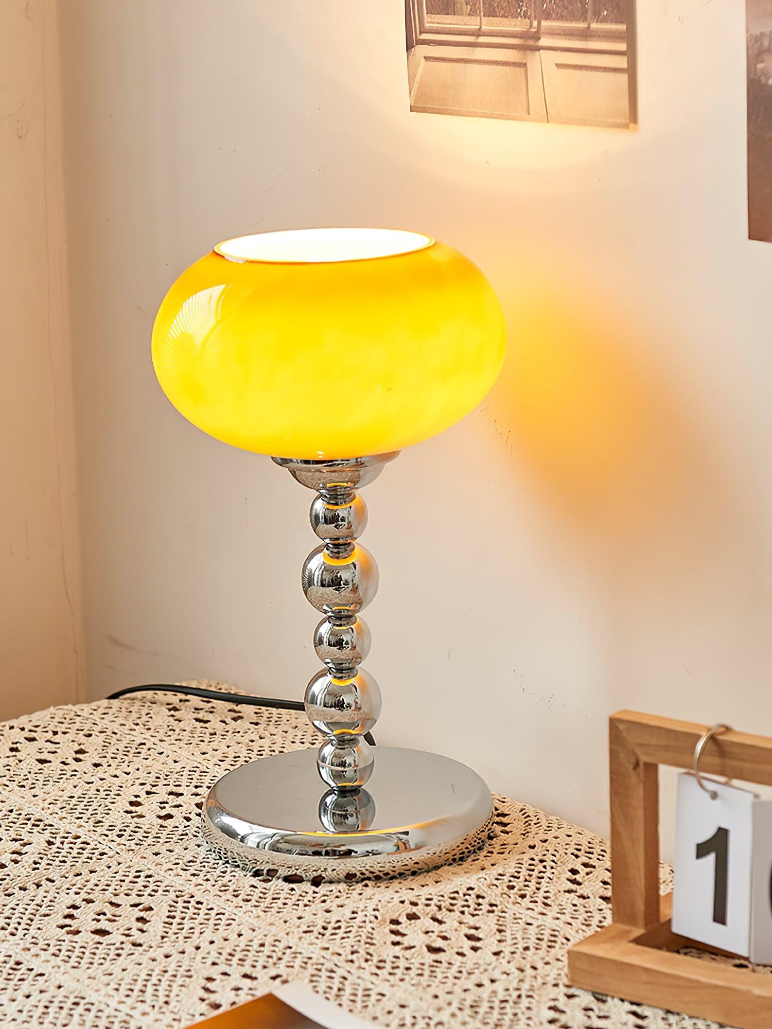 Ciemnopomarańczowa owalna lampa stołowa Persimmon zapalona na stole
