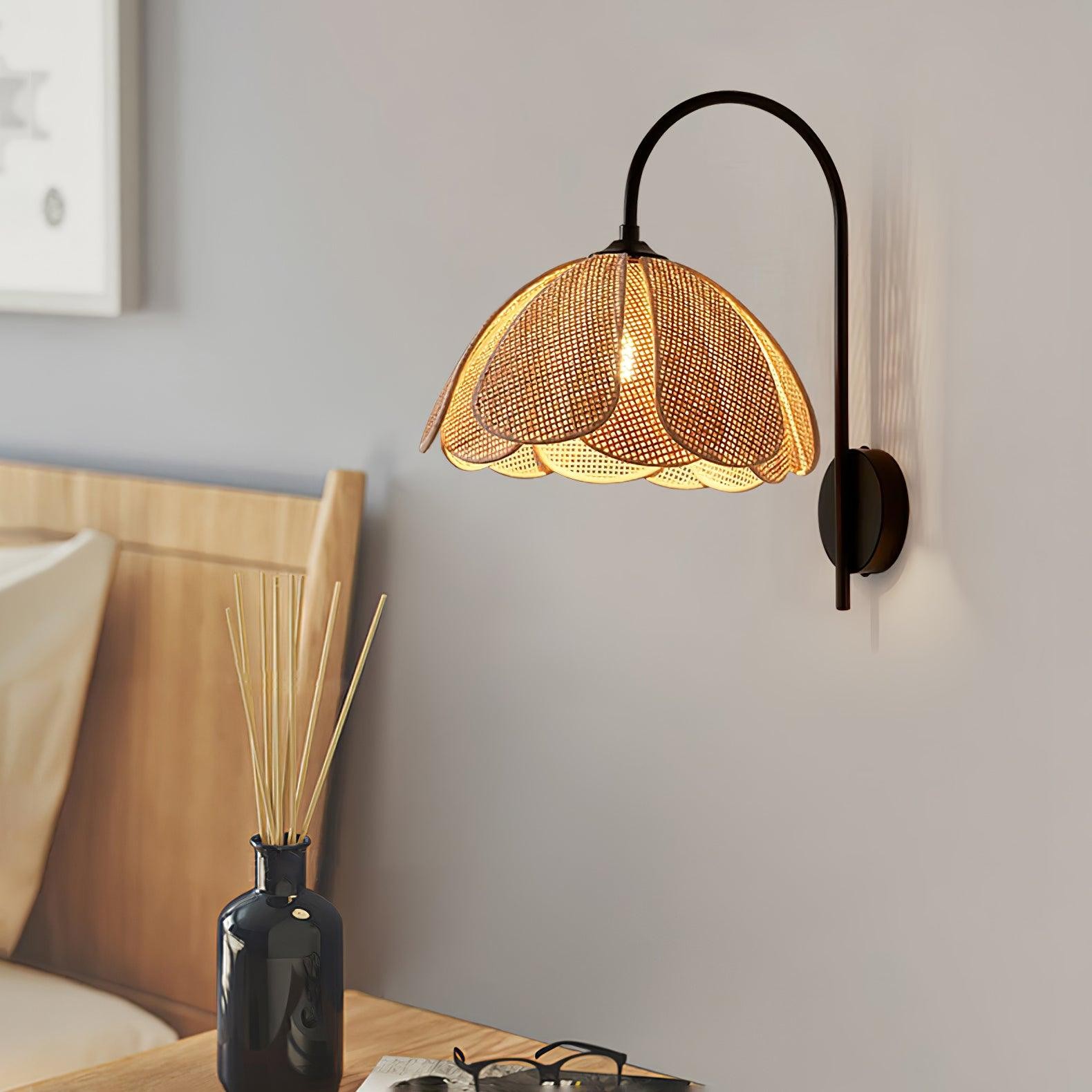 Rattanowa lampa ścienna w kształcie płatków nad stolikiem nocnym