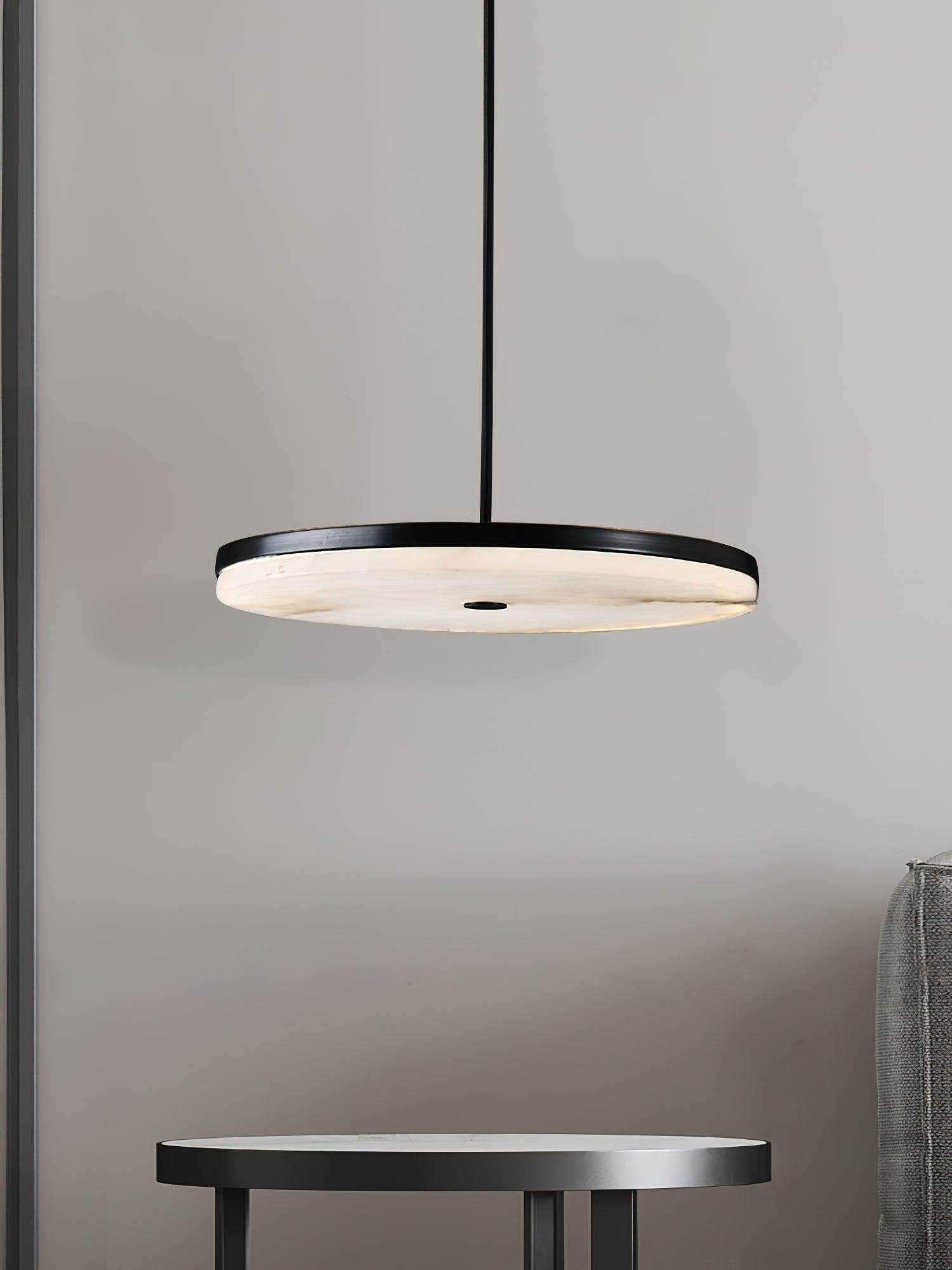Lampa wisząca Wyatt nad małym stołem w minimalistycznym pomieszczeniu