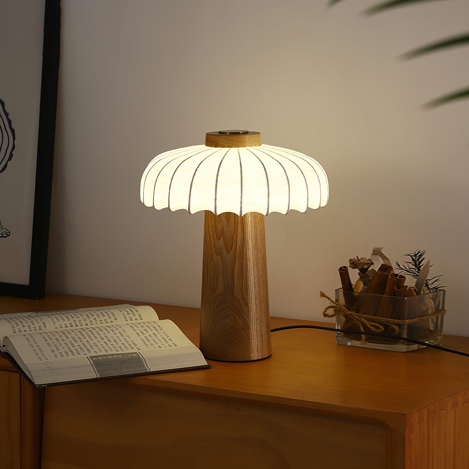 Ciepło oświetlona lampa stołowa Juego w ciemniejszej scenie na biurku