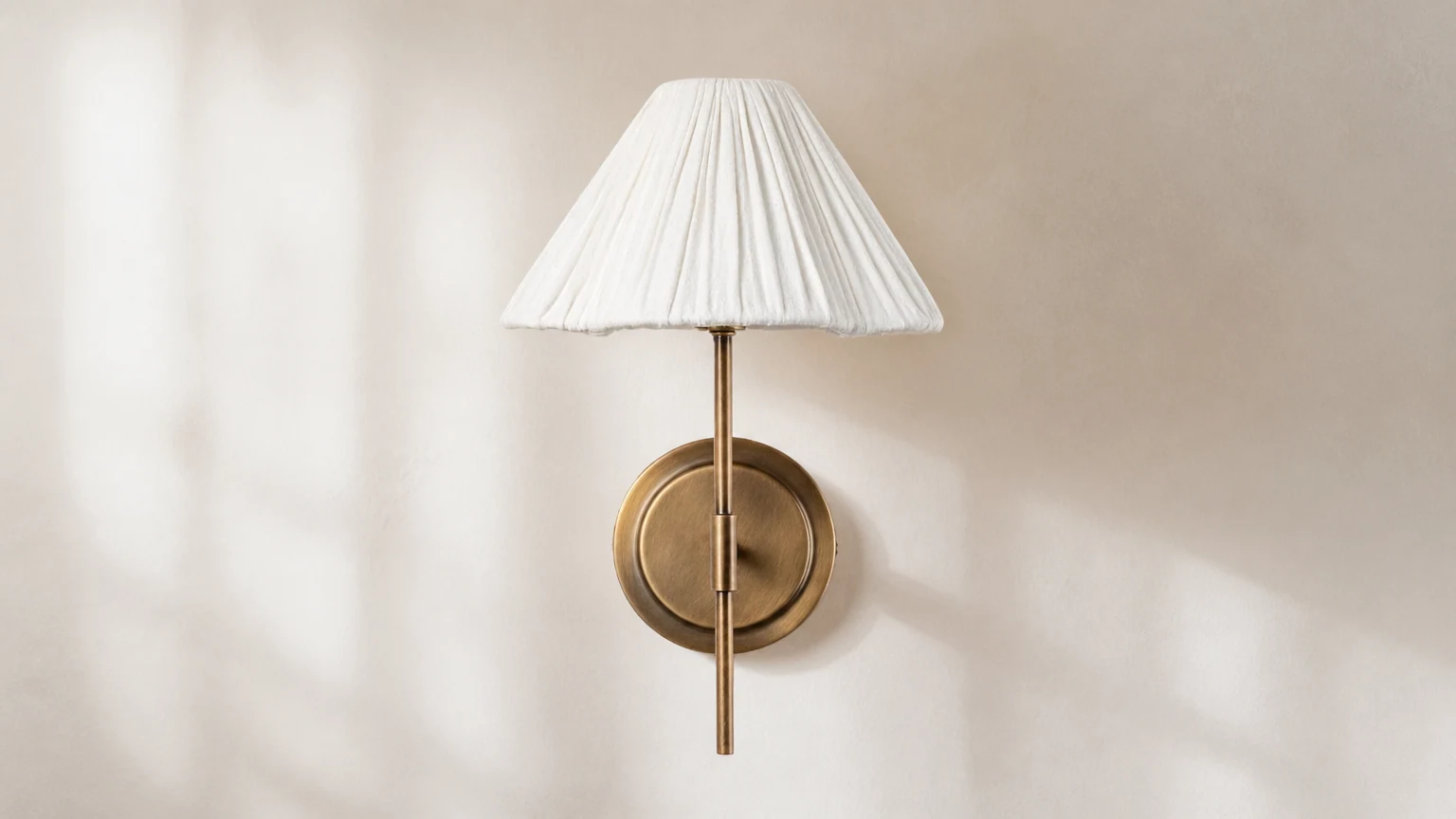 Lampa ścienna Lindi z postarzanego mosiądzu i lnu w ciepłym wnętrzu