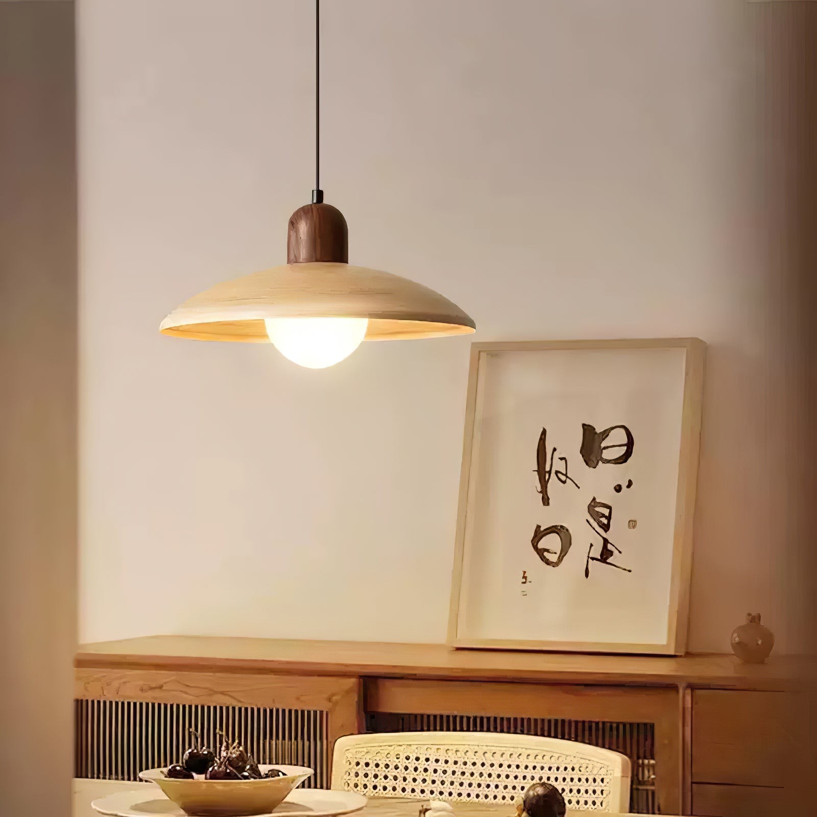 Lampa wisząca oświetlana nad szafką i grafiką ścienną