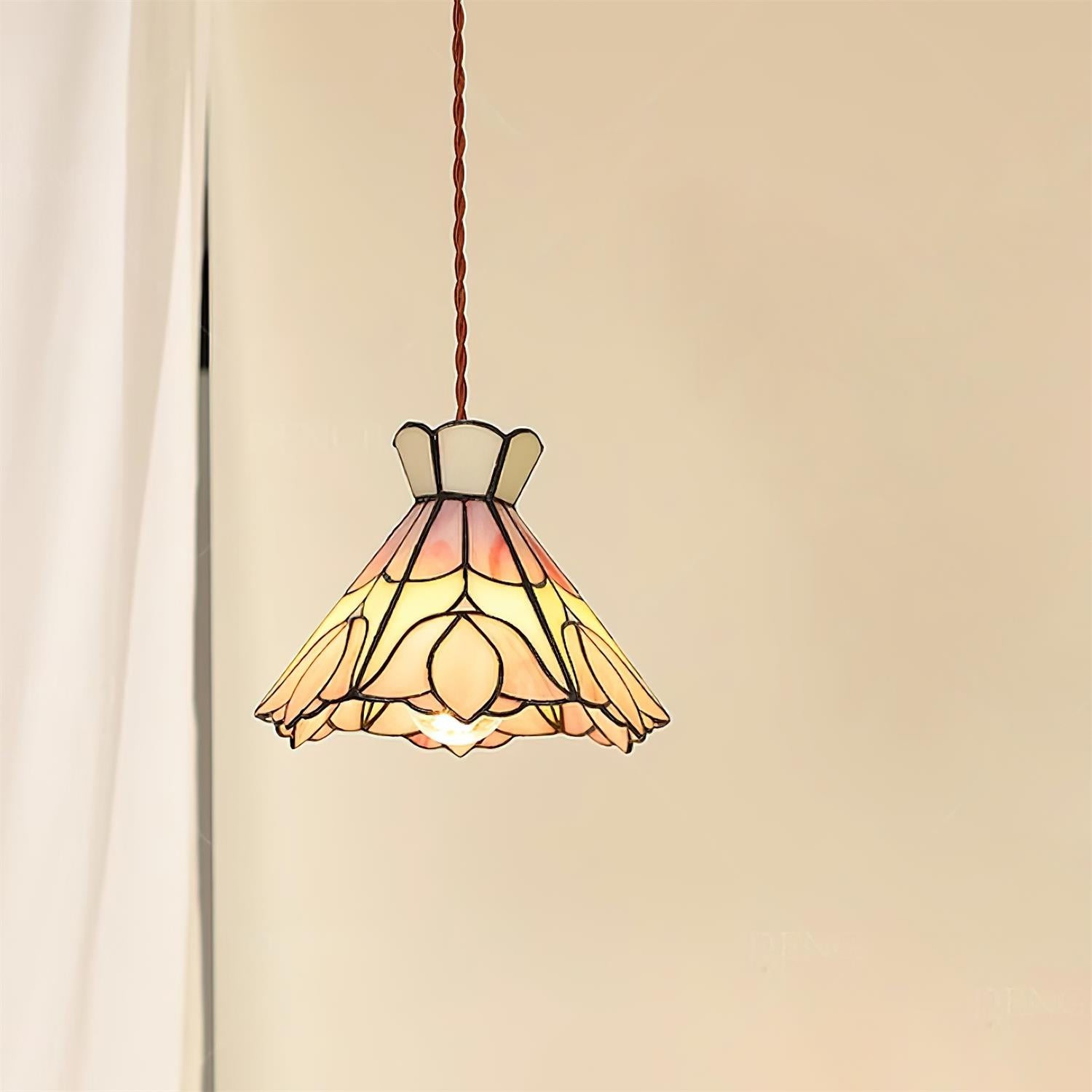Retro lampa wisząca Tiffany świecąca obok zasłony