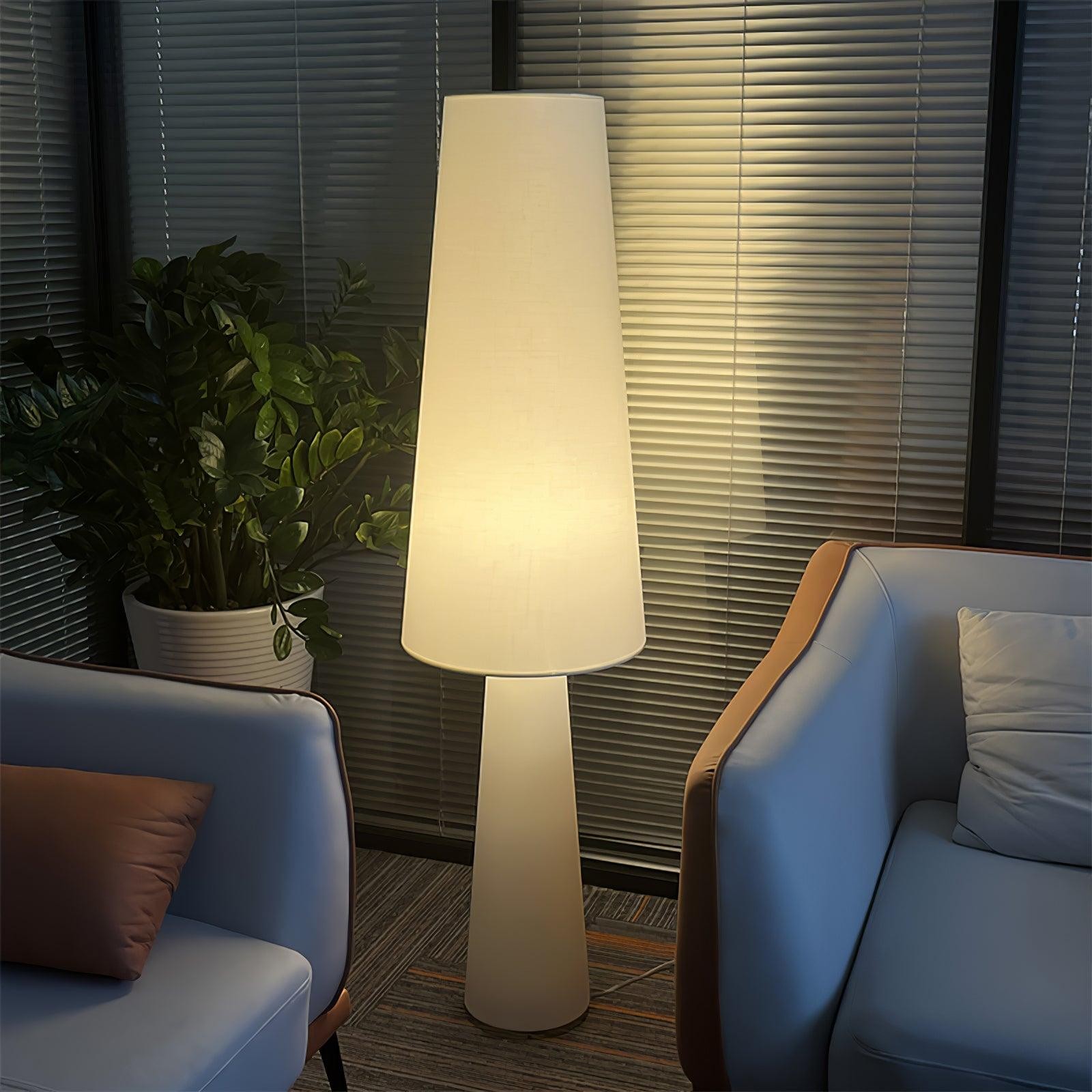 Wysoka świecąca lampa podłogowa M76 umieszczona pomiędzy nowoczesnymi fotelami wypoczynkowymi
