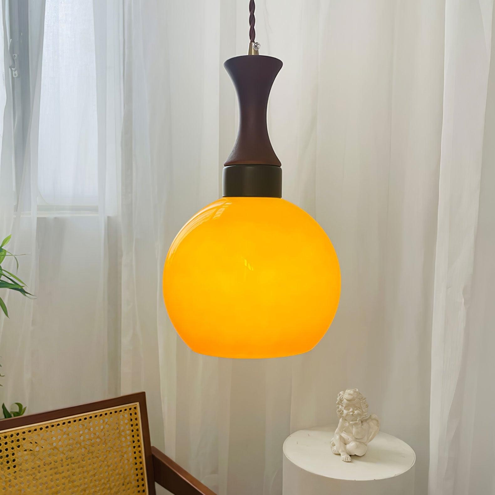 Świecąca kulista pomarańczowa lampa wisząca z zasłonami i stołem