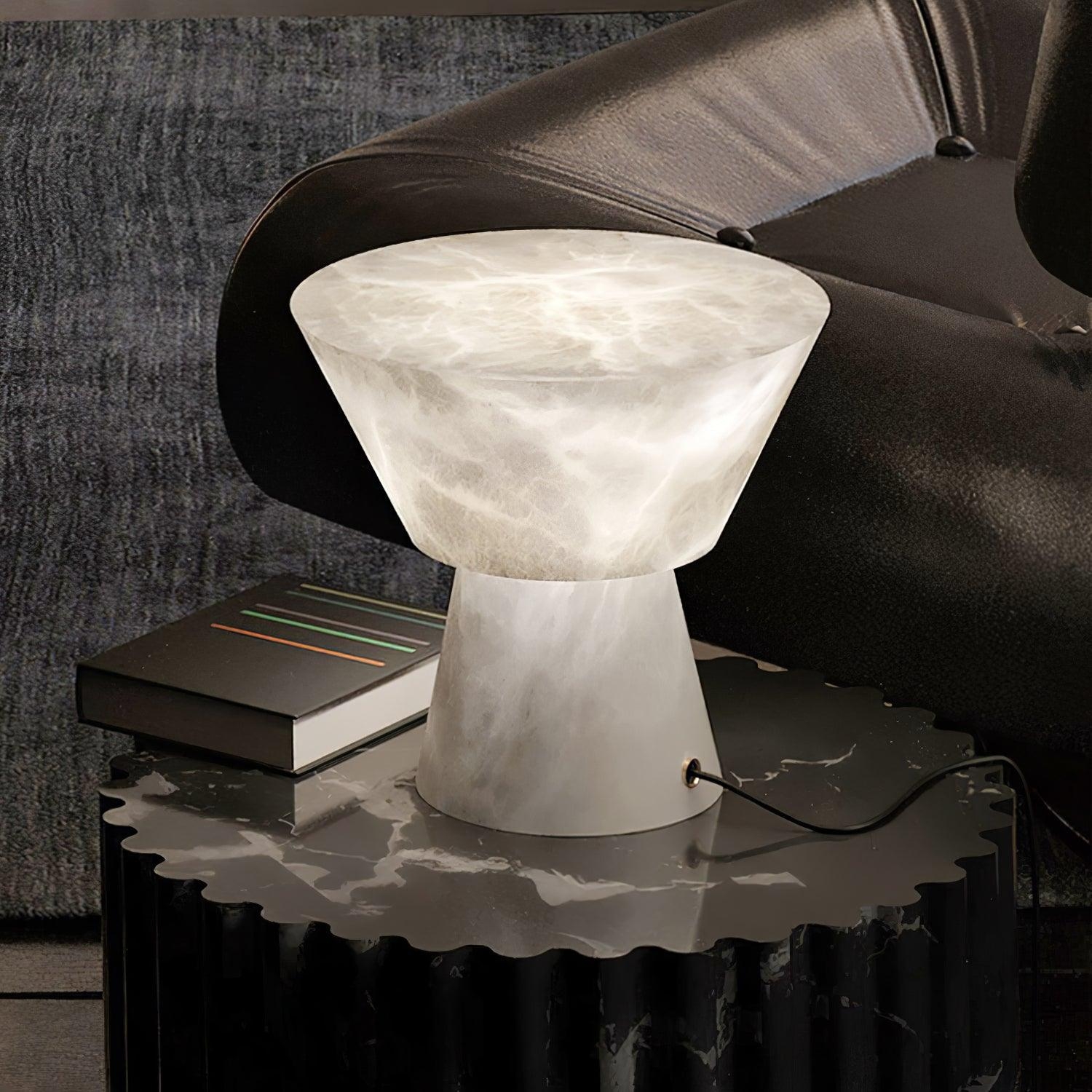 Lampa Beta Marble ustawiona na bocznym stoliku w ciemnym wnętrzu