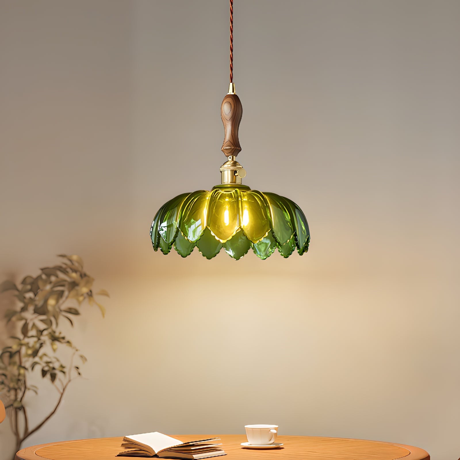Opplyst grønn kronbladslampe over et bord