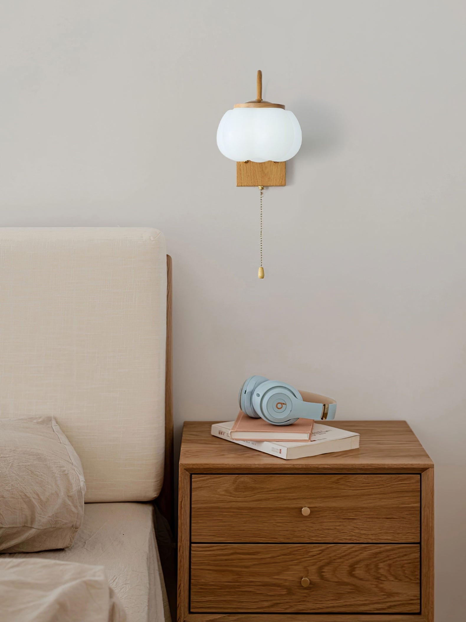 Kinkiet Kapok Flower nad szafką nocną w minimalnej sypialni