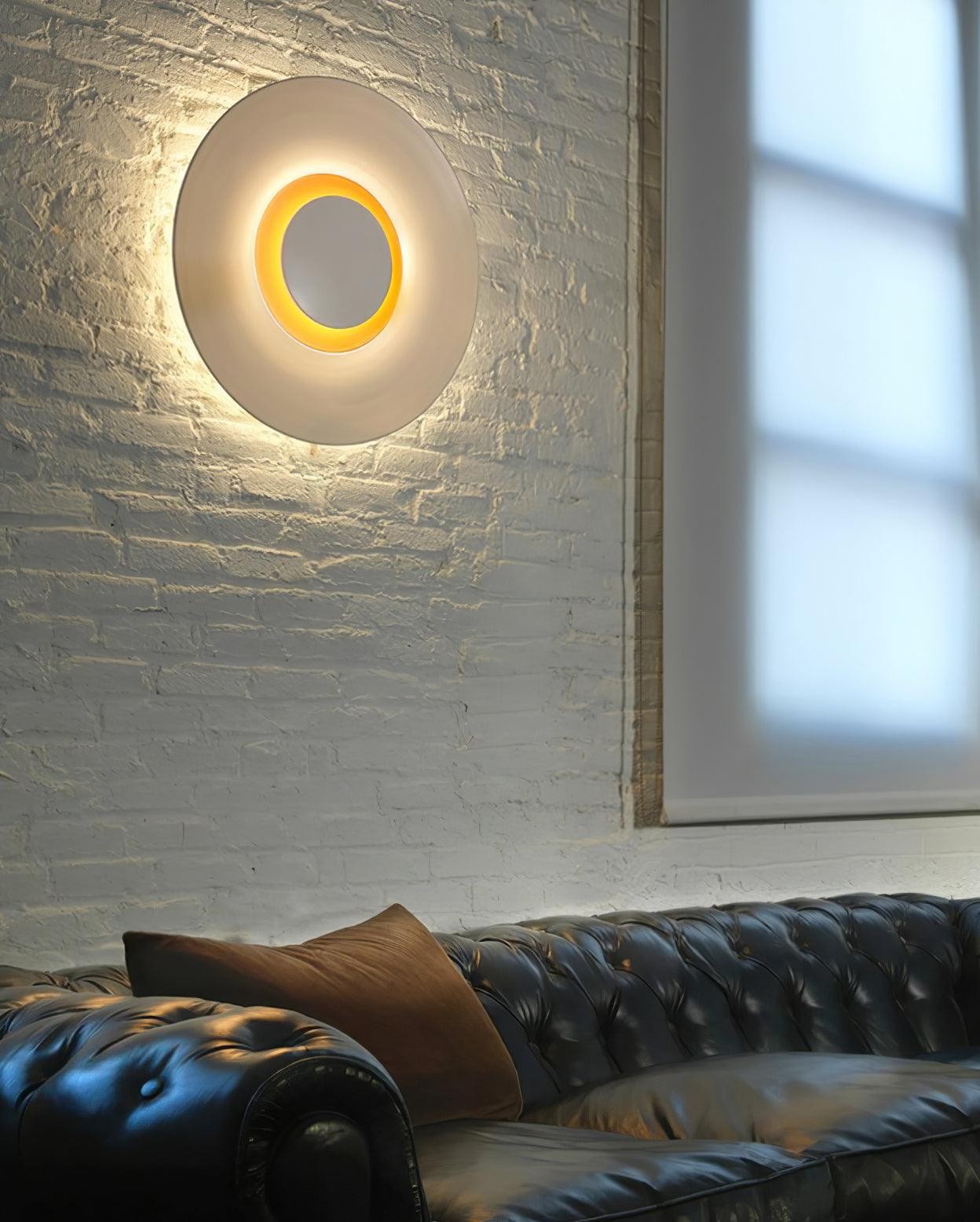 Loungescene med rund vegglampe på teksturert vegg