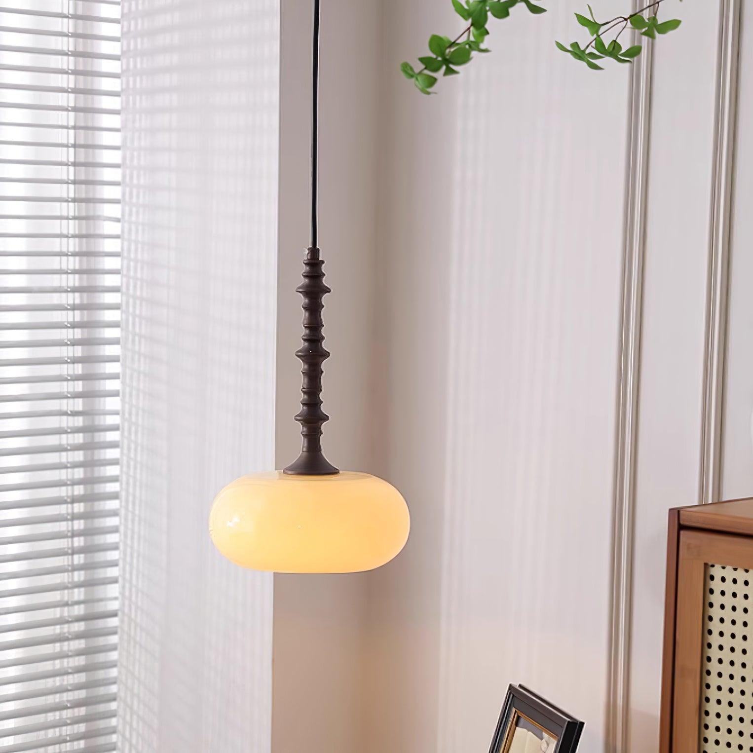 Kremowa lampa wisząca oświetlana w pobliżu okna i mebli