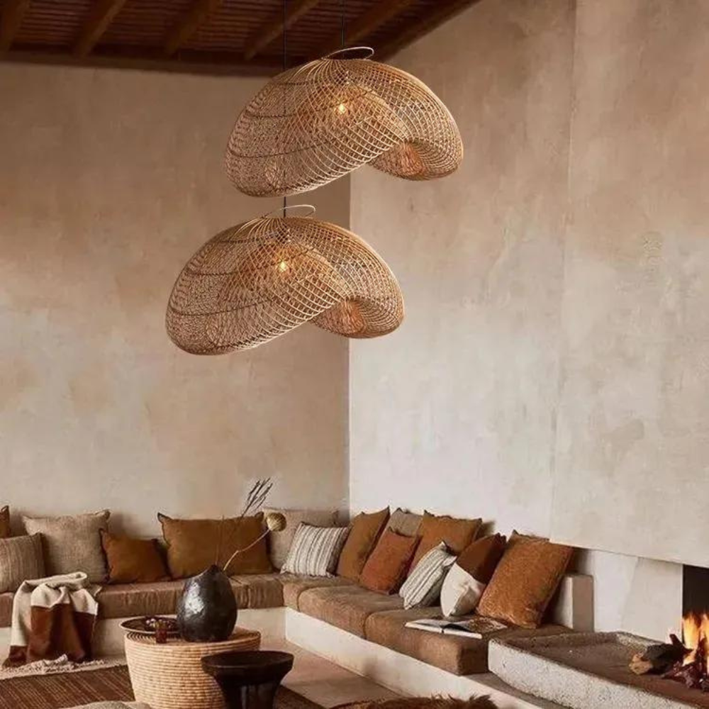 Par de lámparas colgantes de ratán estilo Wabi-Sabi sobre una zona de estar.