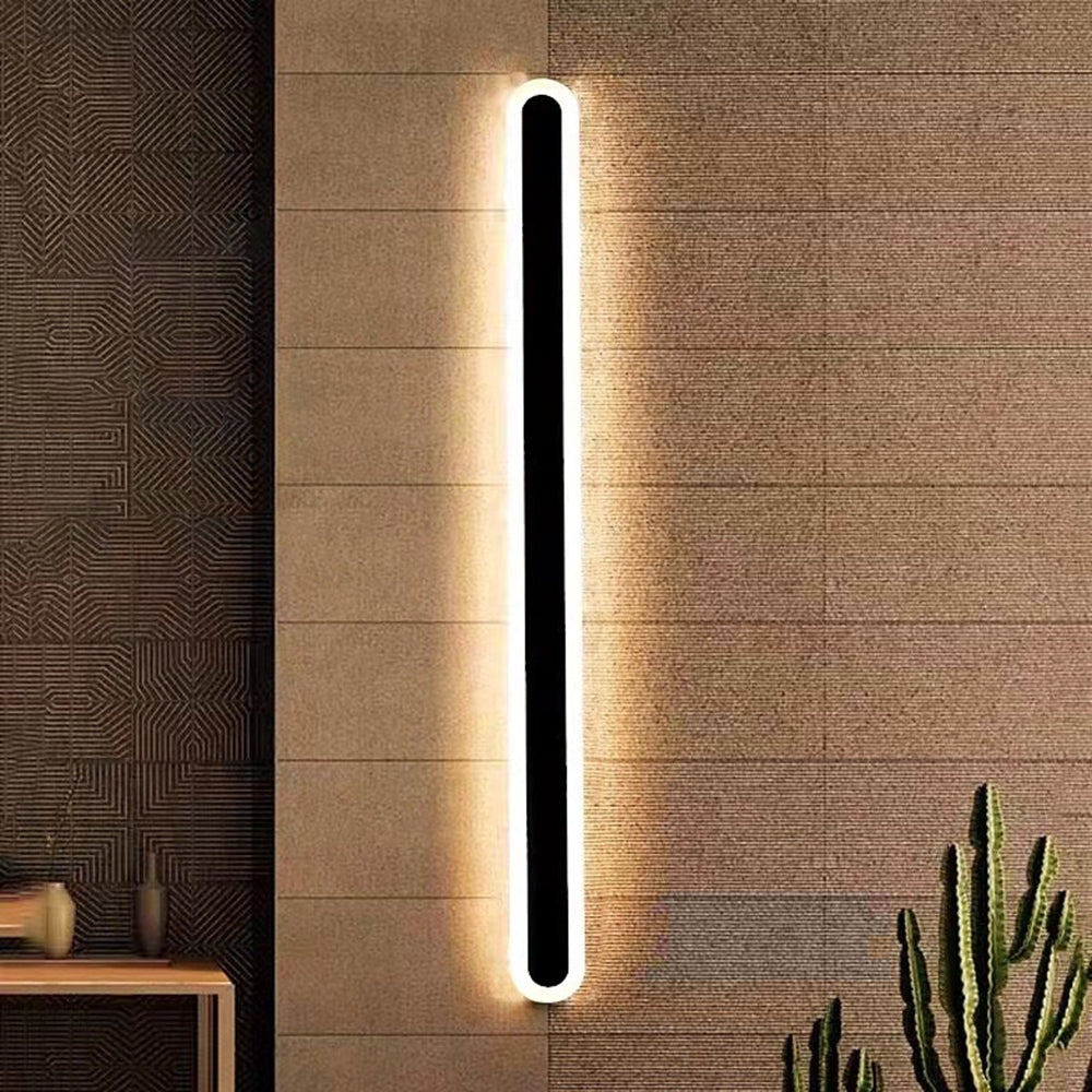 Lampa ścienna Edge zainstalowana na ścianie z teksturą, zapewniająca ciepłe oświetlenie