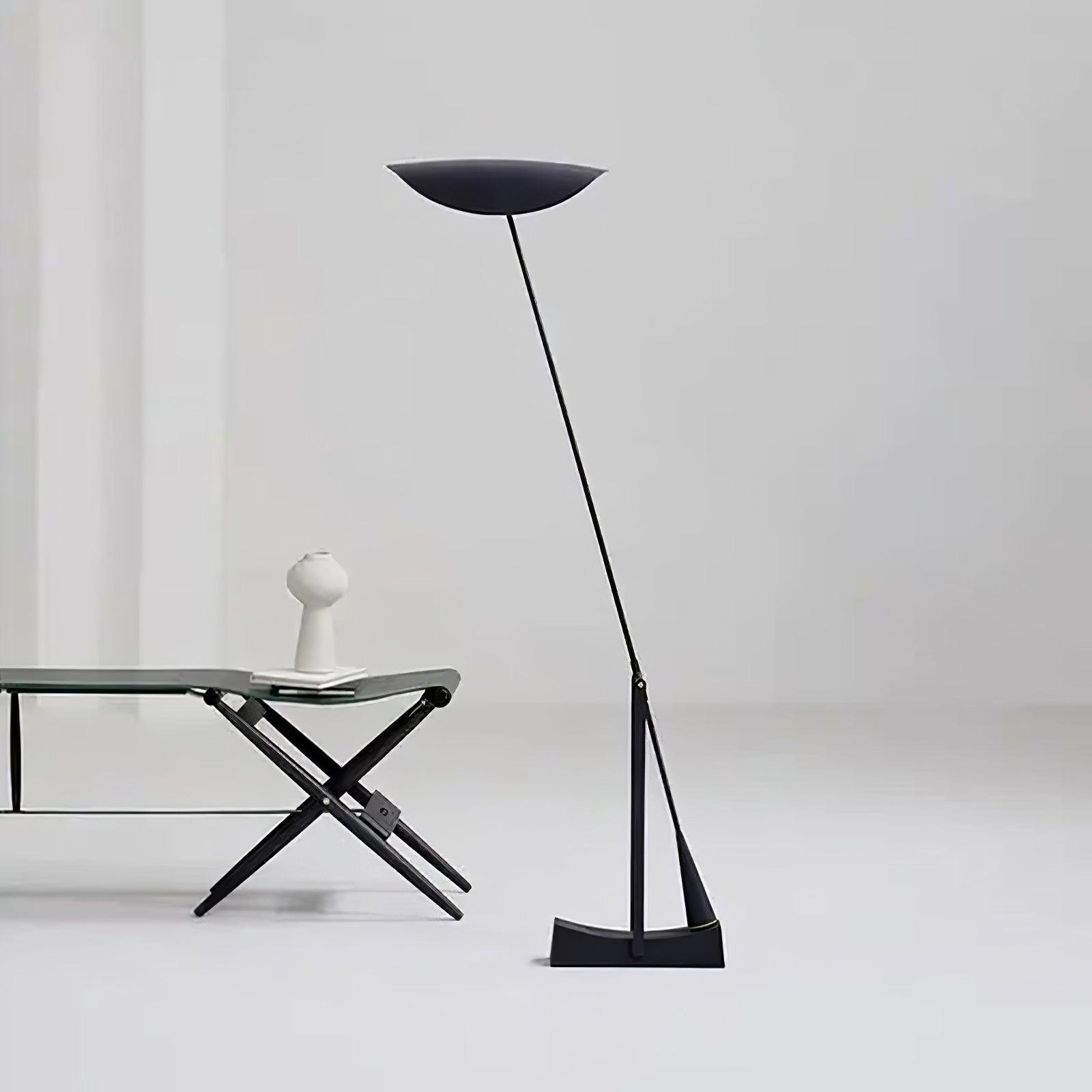 Pochylona lampa w minimalnej oprawie ze stołem