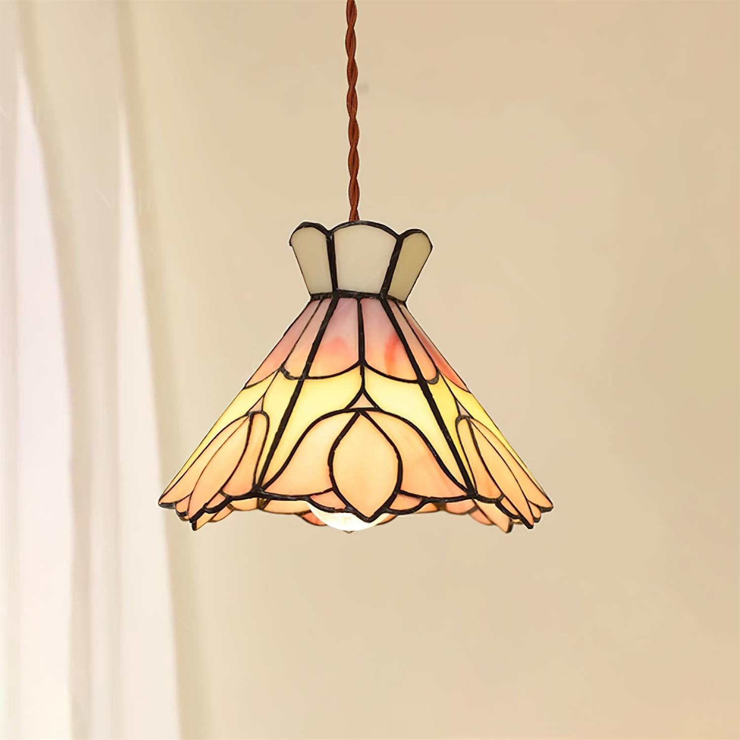 Lampa wisząca retro Tiffany zapalona obok zasłony