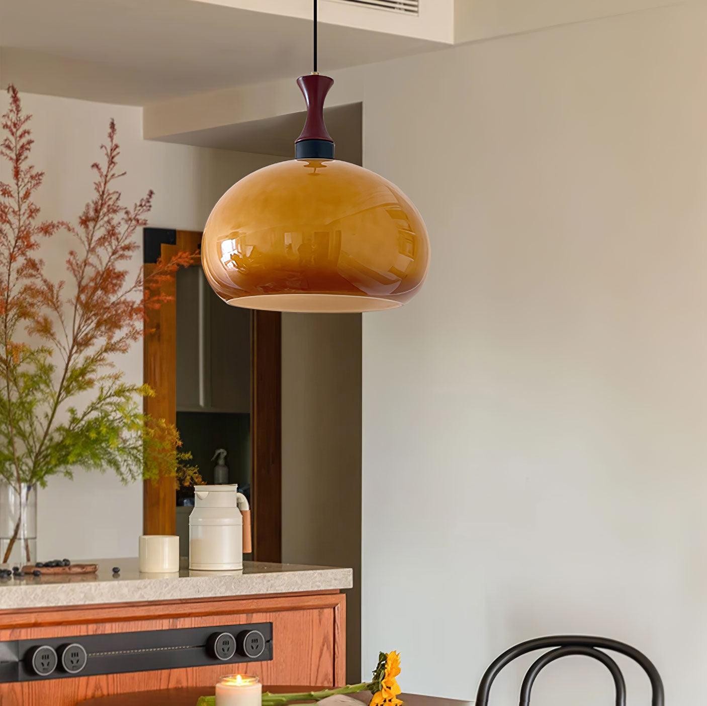 Pomarańczowa lampa wisząca zainstalowana nad konsolą