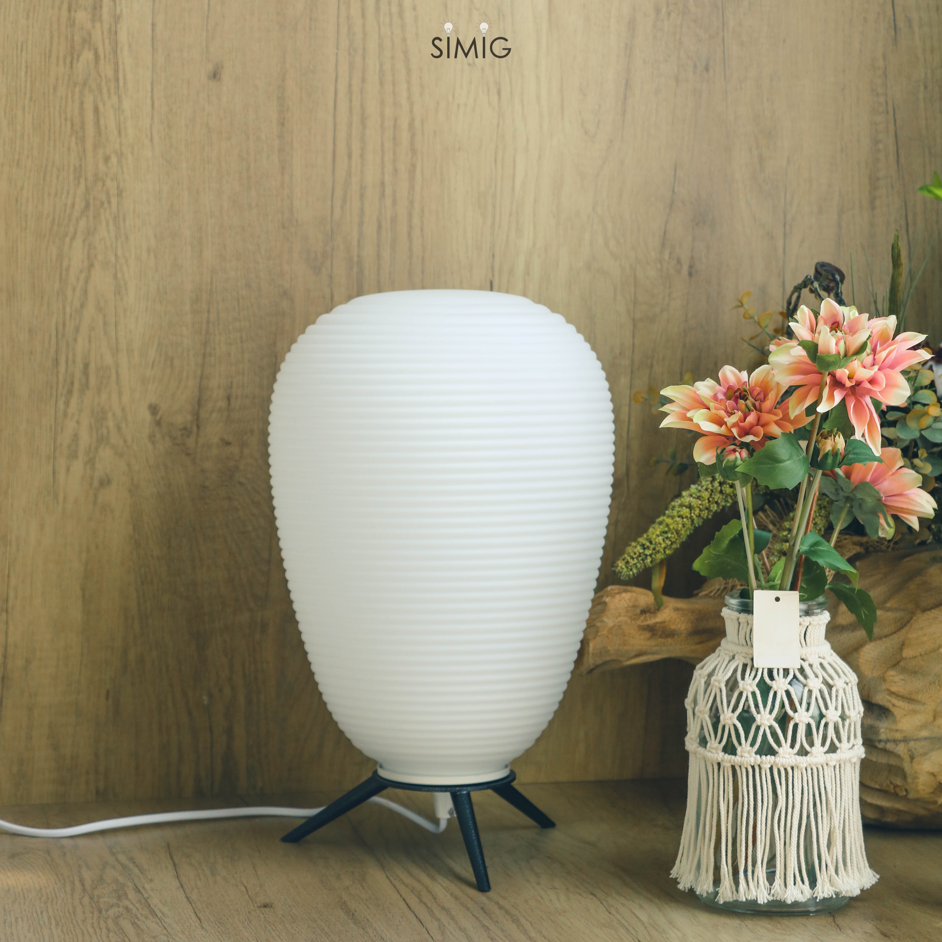 Lamp on wooden surface with vase