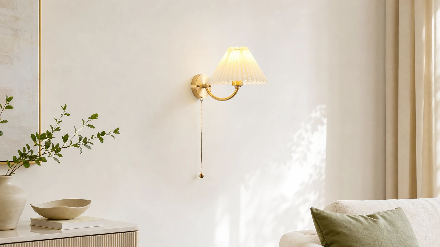 Nowoczesna mosiężna lampa ścienna z białym plisowanym abażurem z tkaniny w ciepłej scenerii wnętrza