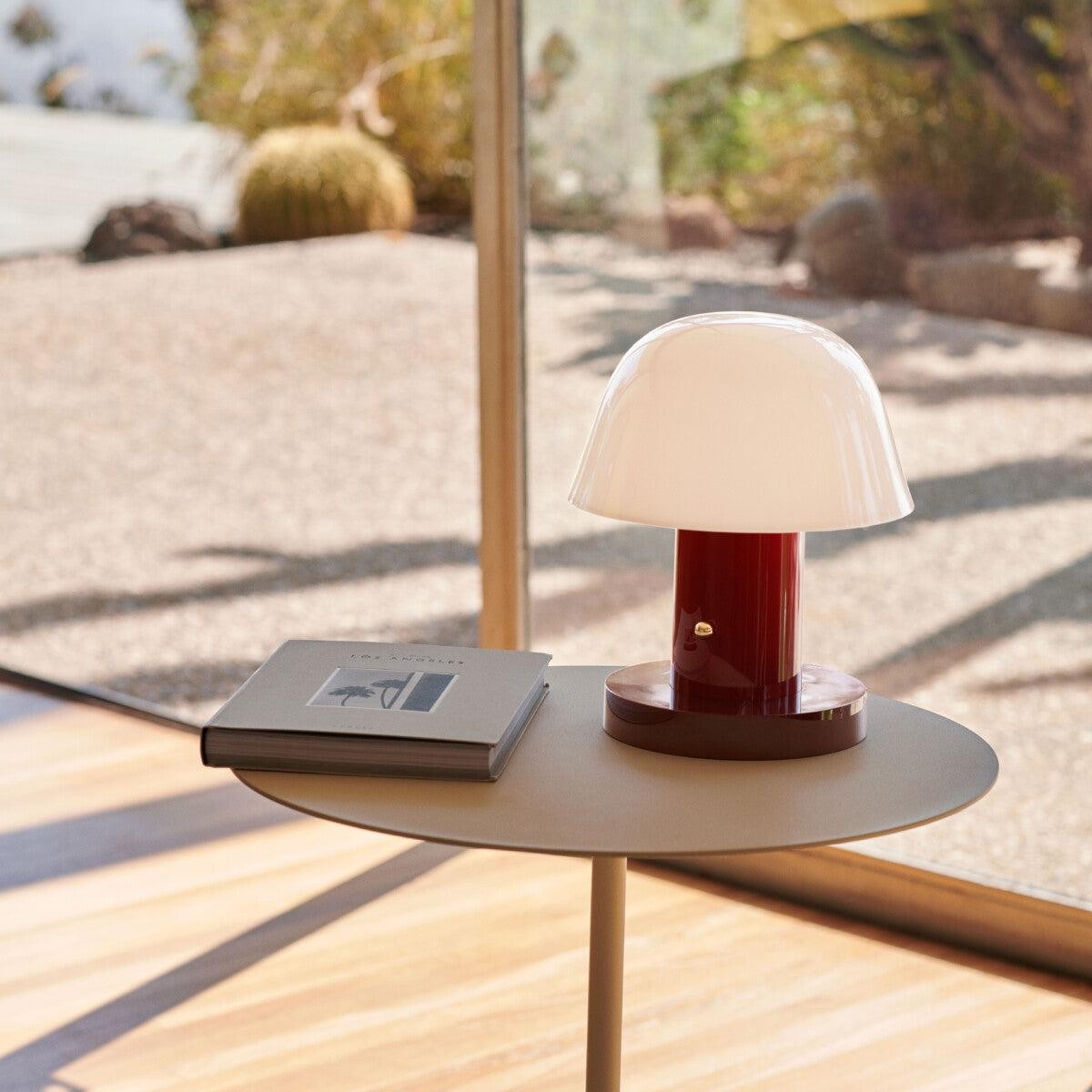 Sopplignende trådløs lampe på et lite bord