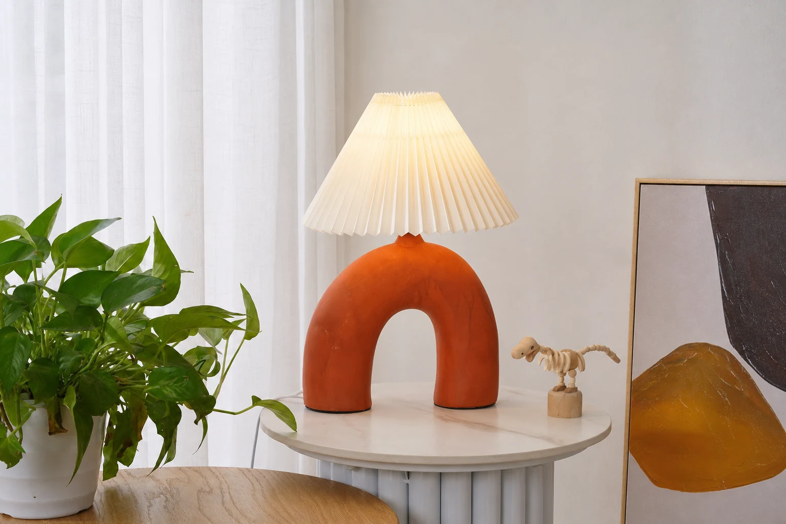 Scena w stylu lifestylowym z plisowaną lampą stołową w kształcie łuku M495