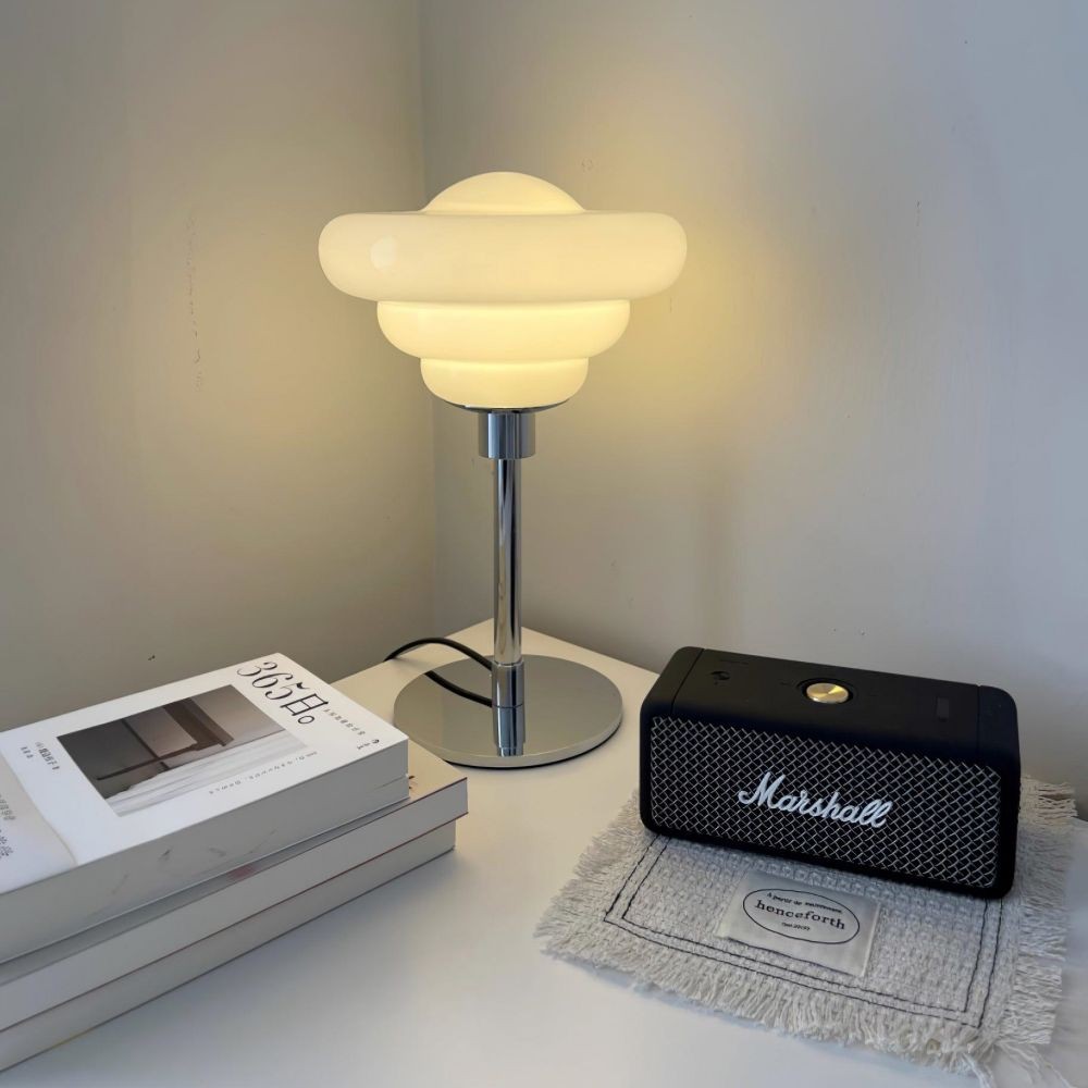 Kremowo-żółta lampa S80 na blacie z książkami i głośnikiem