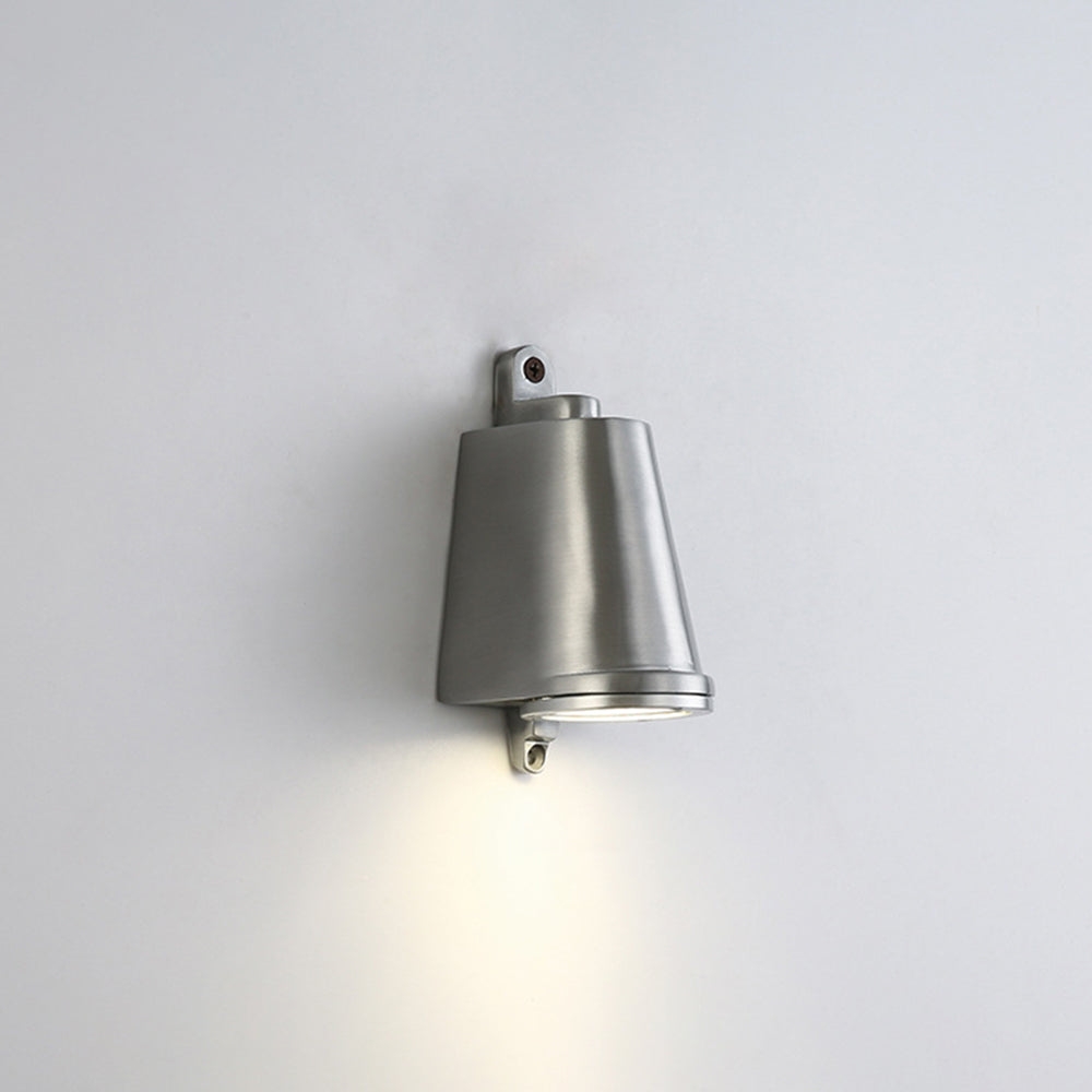 Vista de cerca de la lámpara de pared tipo campana instalada con haz de luz cálido en la pared.