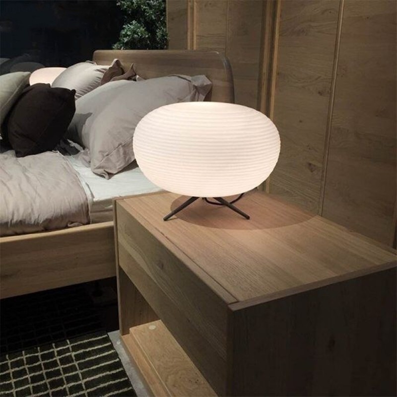 Lamp on bedside table beside bed