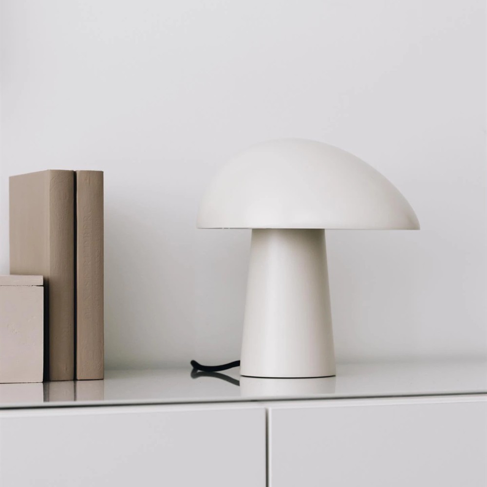 Vit nattuggla bordslampa på ett skåp med böcker
