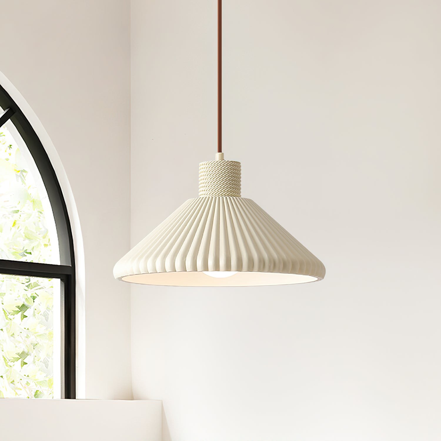 Lampa wisząca w paski pokazana w pobliżu łukowatego okna