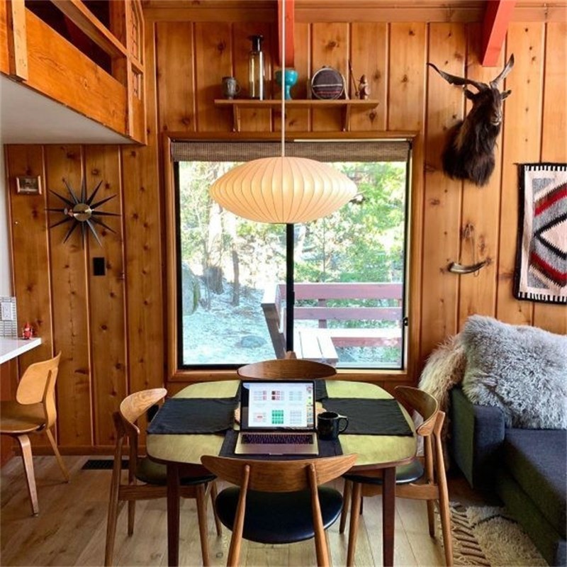 Lámpara colgante con forma de platillo en un cálido interior de madera.