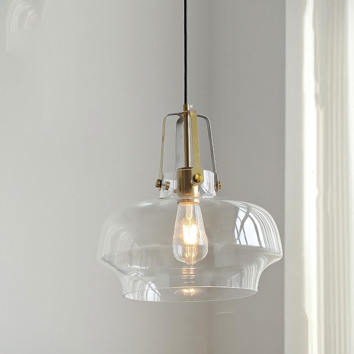 Przezroczysta lampa wisząca kontrastująca z jasnym wnętrzem