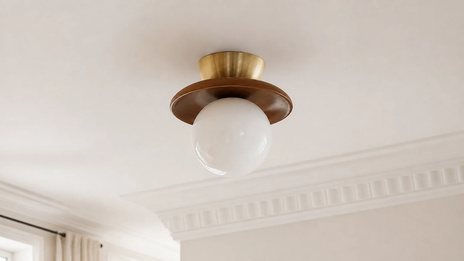 Treskål og hvit globeformet taklampe installert i et varmt interiør