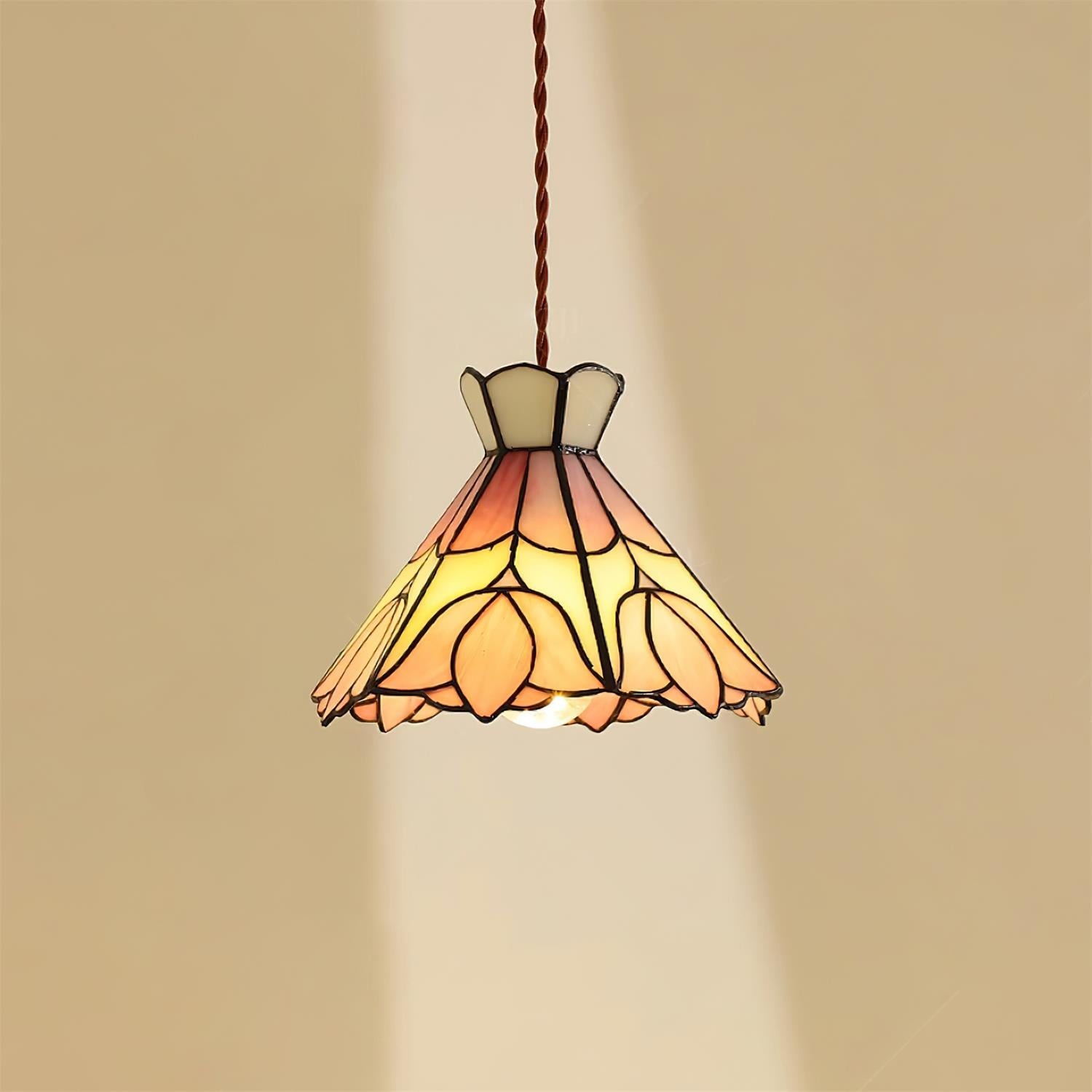 Lampa wisząca retro Tiffany oświetlana na neutralnej ścianie