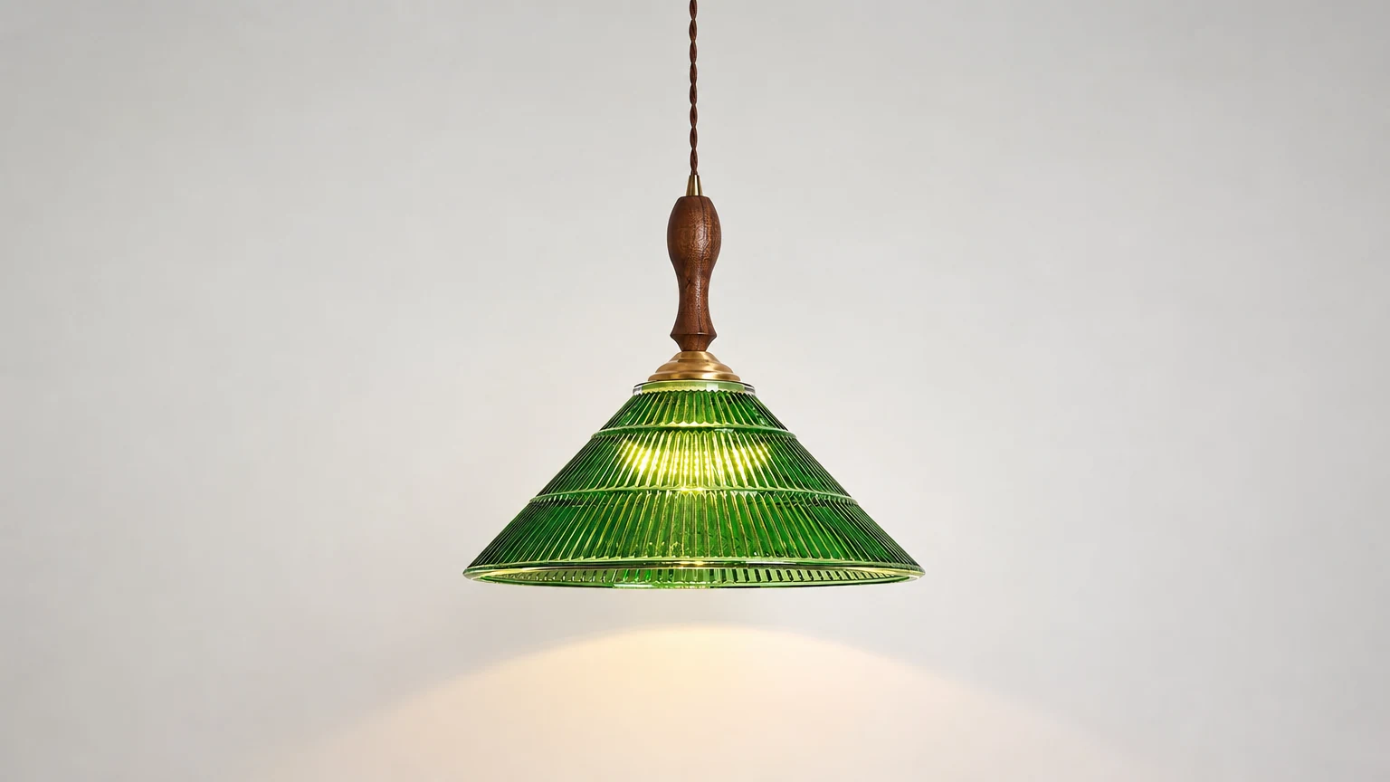 Zielona lampa wisząca Nolyn D135 w ciepłej scenerii wnętrza