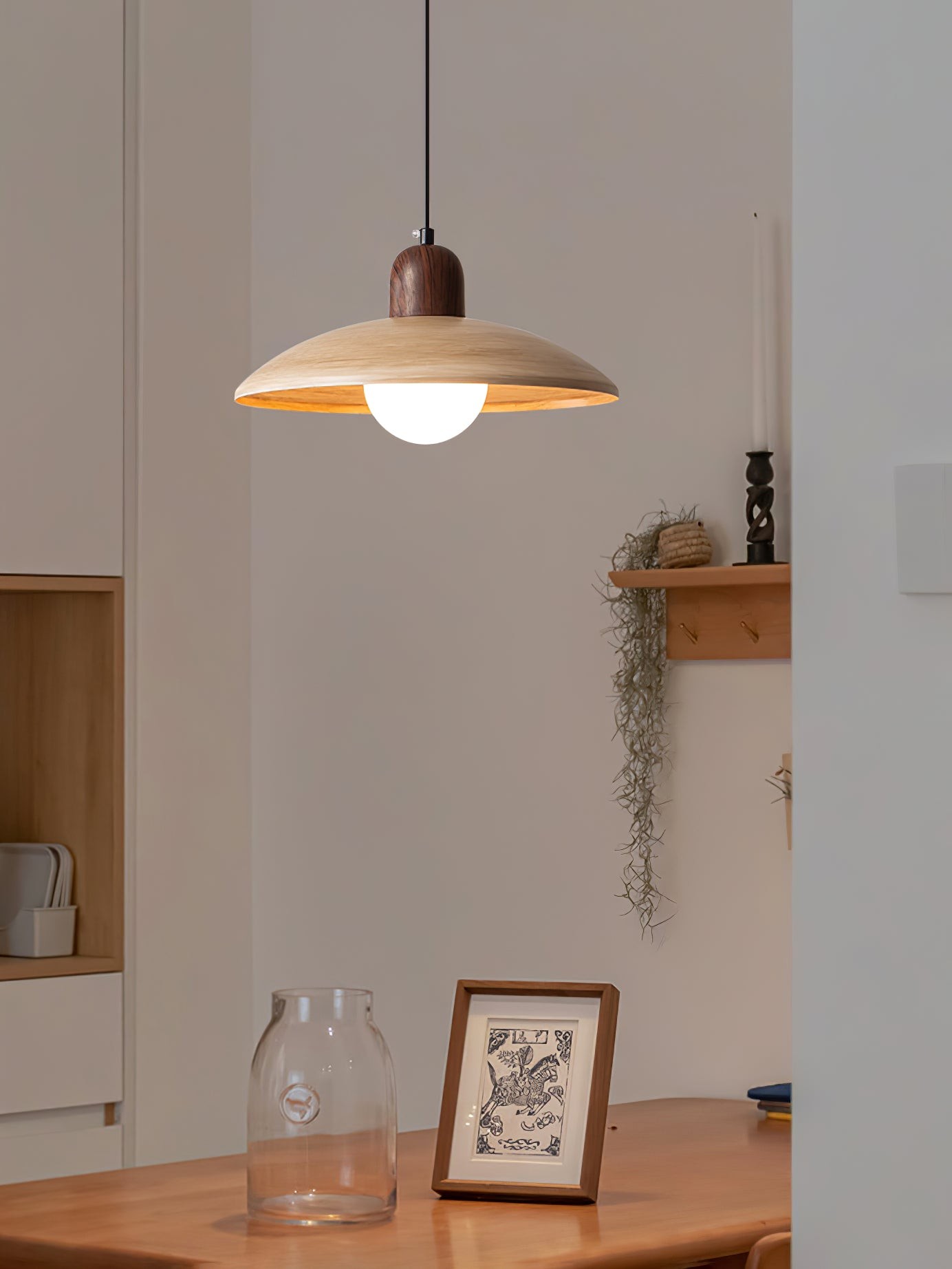 Lampa wisząca w minimalistycznym wnętrzu z dekoracją stołu i ściany