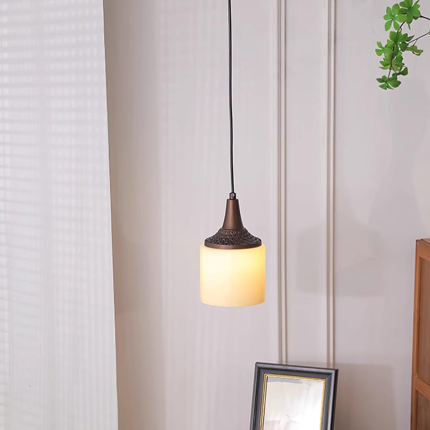 Cylindryczna lampa wisząca oświetlana w miękkiej kurtynie wnętrza