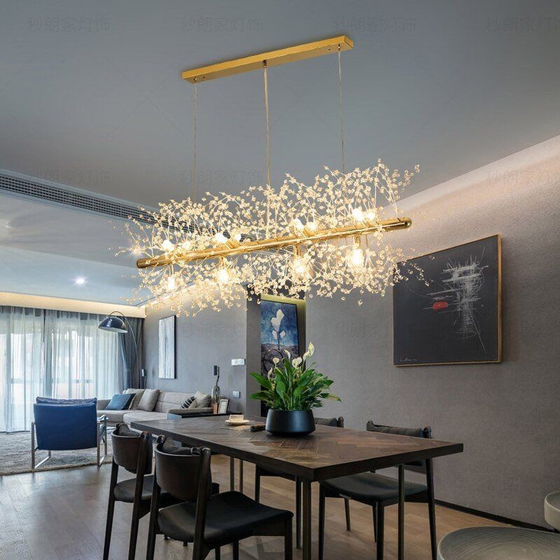 Lámpara de araña de cristal iluminada sobre una mesa de comedor en un cálido comedor.